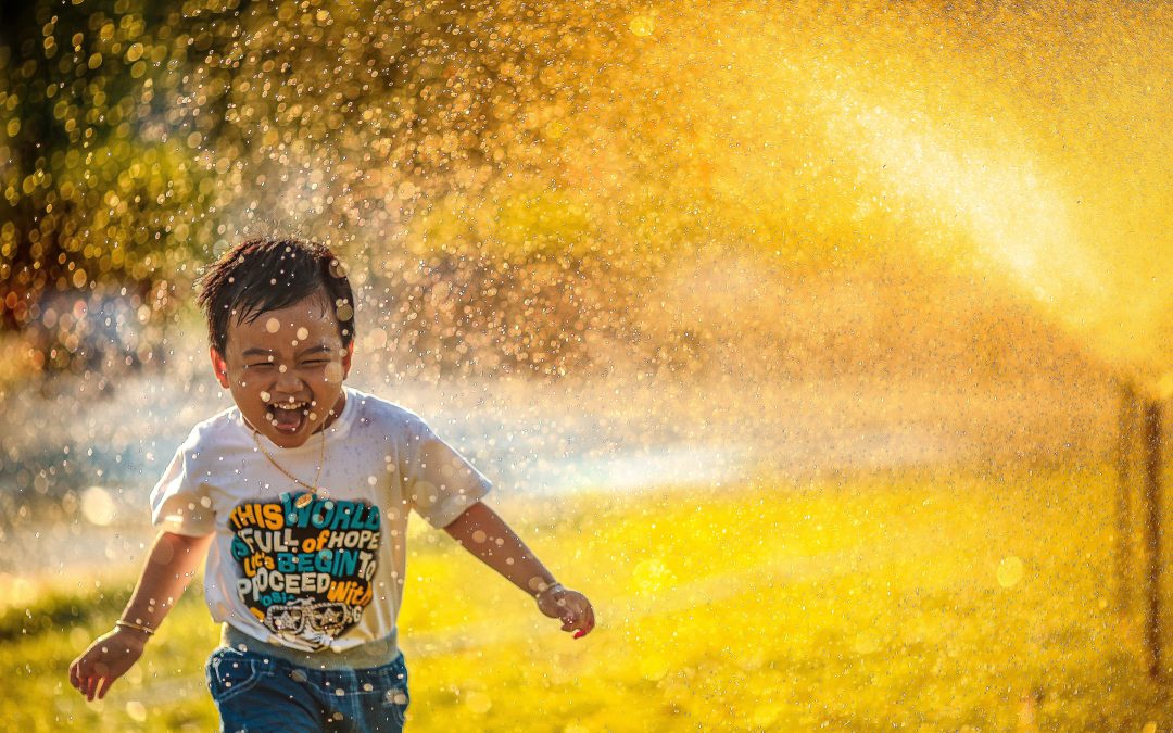 child running through sprinkler