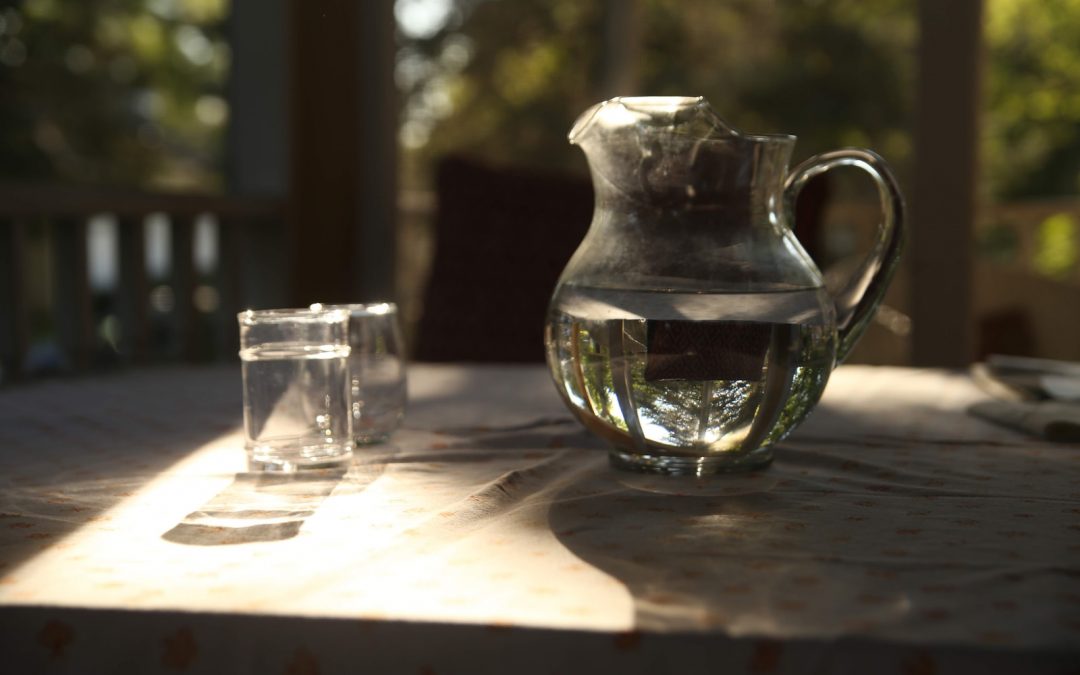 clear glass pitcher beside clear drinking glass on table
