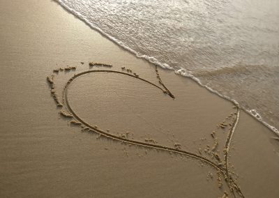 handwritten heart on sand