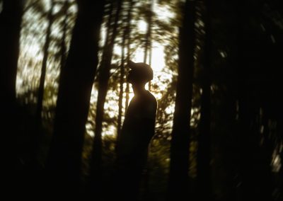silhouette of person standing in forest during daytime