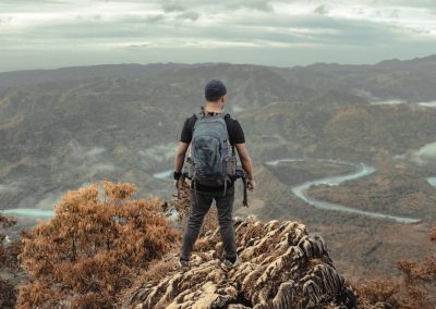 a man standing on top of a mountain with a backpack