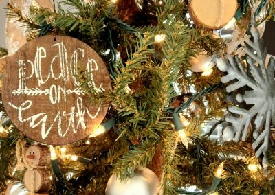 a christmas tree with ornaments and a wooden sign