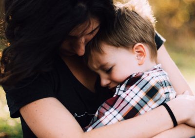 woman hugging boy on her lap