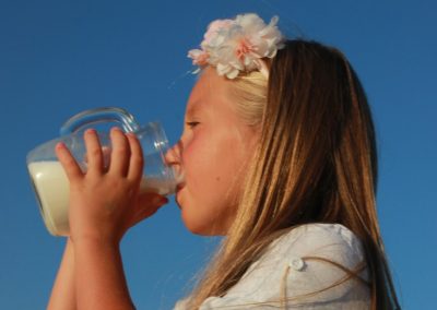 a young girl drinking from a bottle of milk