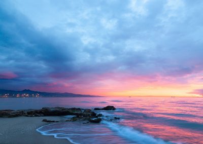 waves of body of water splashing on sand