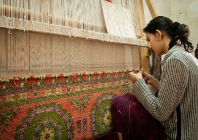 a woman is working on a weaving machine