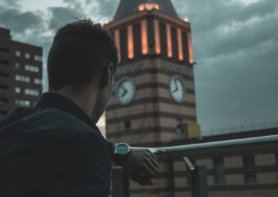 man in black jacket standing near brown building during daytime