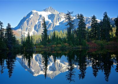 A mountain is reflected in the still water of a lake