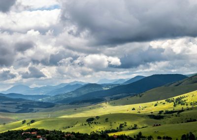 green grass field under white clouds during daytime