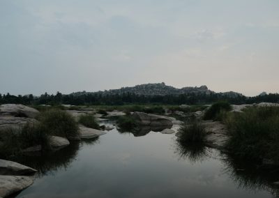 a small pond surrounded by rocks and grass