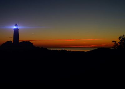 silhouette of lights on lighthouse during golden hour