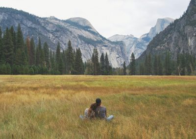 two person sitting on grass field